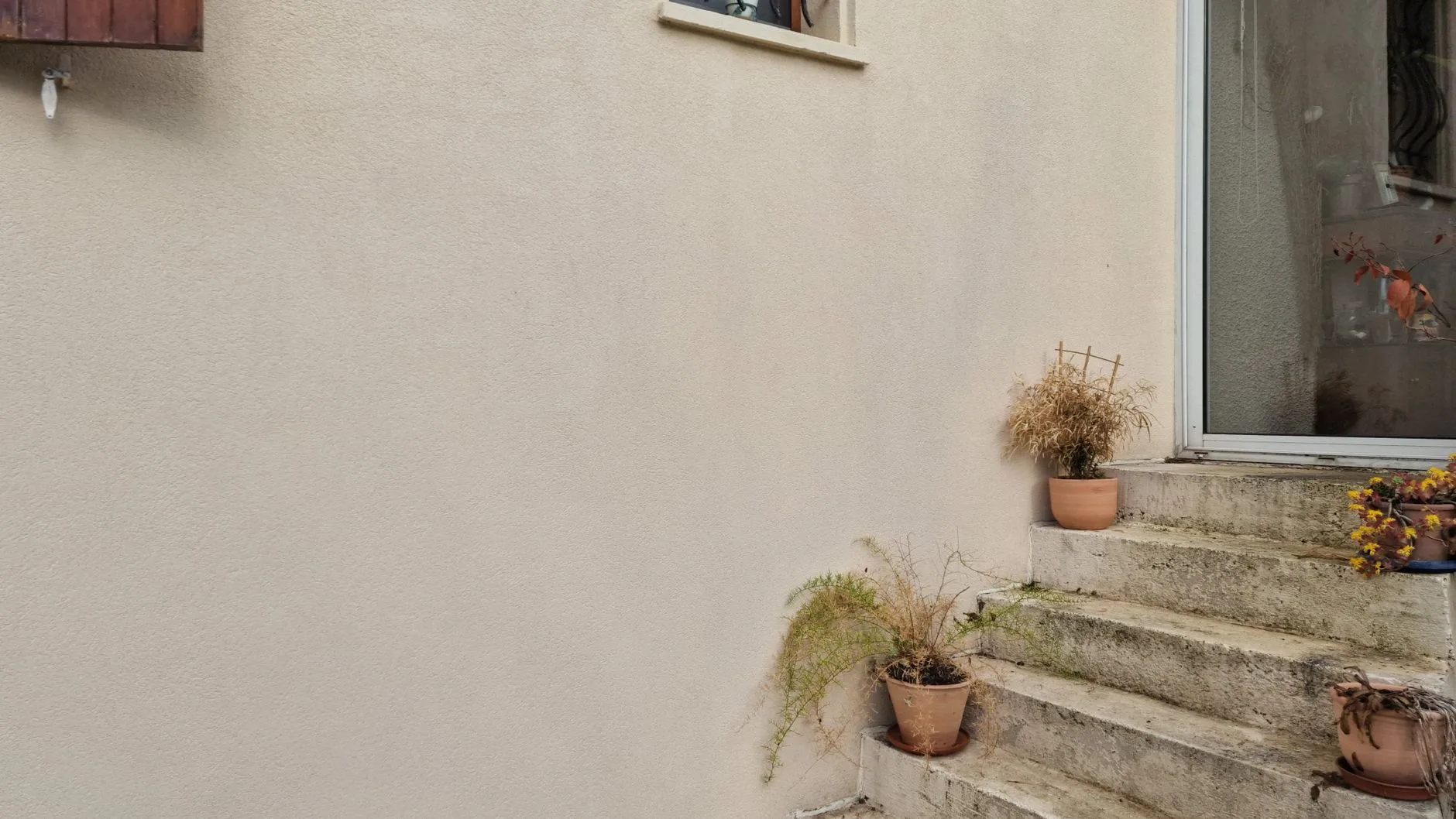 Fissure sur un mur de façade suivant les joints de parpaings, mesurée au réglet